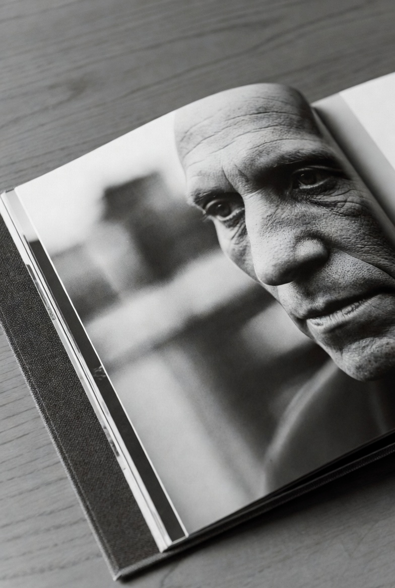 Artistic black and white photograph of an open book featuring a dramatic portrait